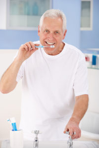Senior man brushing teeth.