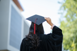 a person holding a their graduation cap