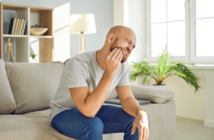 a man holding his mouth in pain